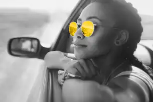 frau mit gelber sonnenbrille lehnt aus auto seitenfenster, hertz autovermietung