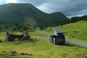 Campervan am Wegrand auf der Isle of Mull mit grüner Wiese und Berg im Hintergrund
