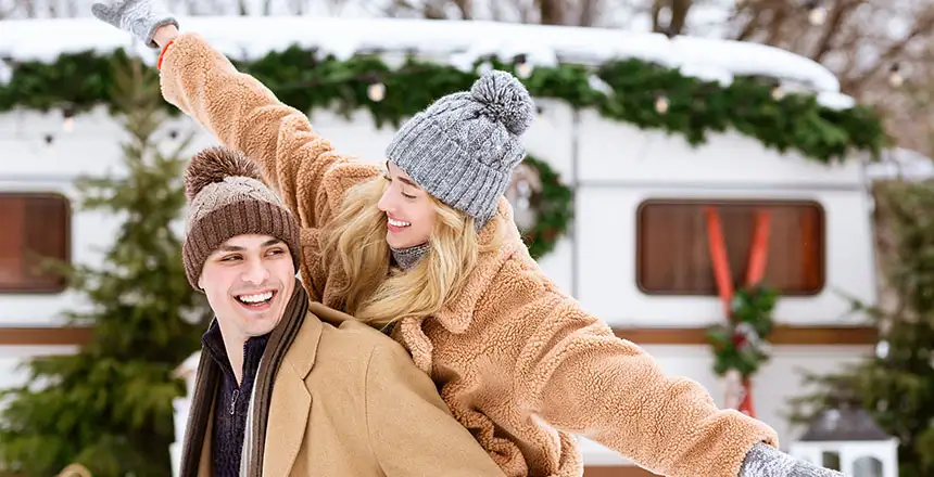 pärchen genießt den winterzauber beim camping mit wohnmobil