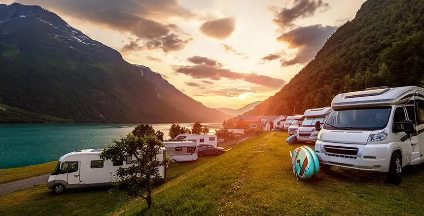 Wohnmobile am See in den Bergen bei goldenem Abendlicht