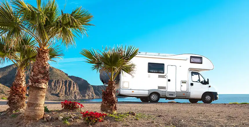 mit wohnmobil in andalusien vor palmen am strand in spanien