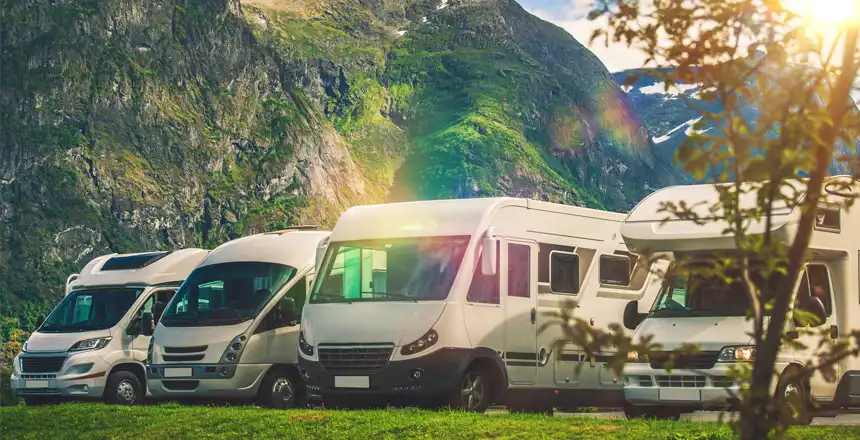 Verschiedene Wohnmobile auf Wiese in den Bergen