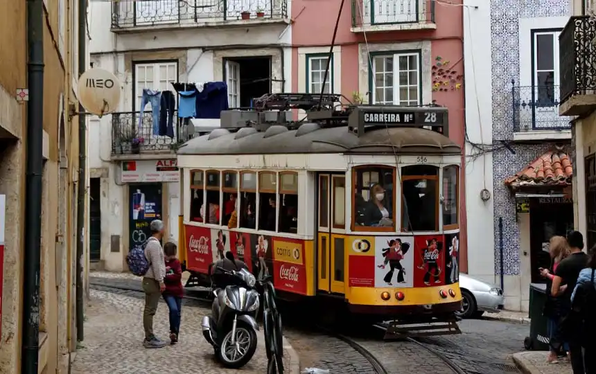 portugal-lissabon-strassenbahn-motorrad Straßenbahn in Lissabon mit Motorroller im Vordergrund