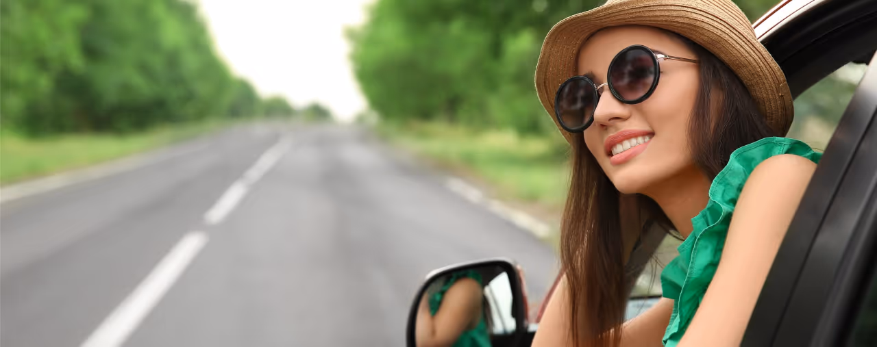 frau mit grünem shirt schaut aus auto seitenfenster