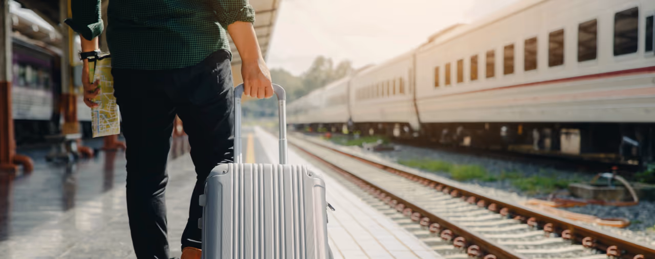 Reisender mit Koffer am Bahnhof
