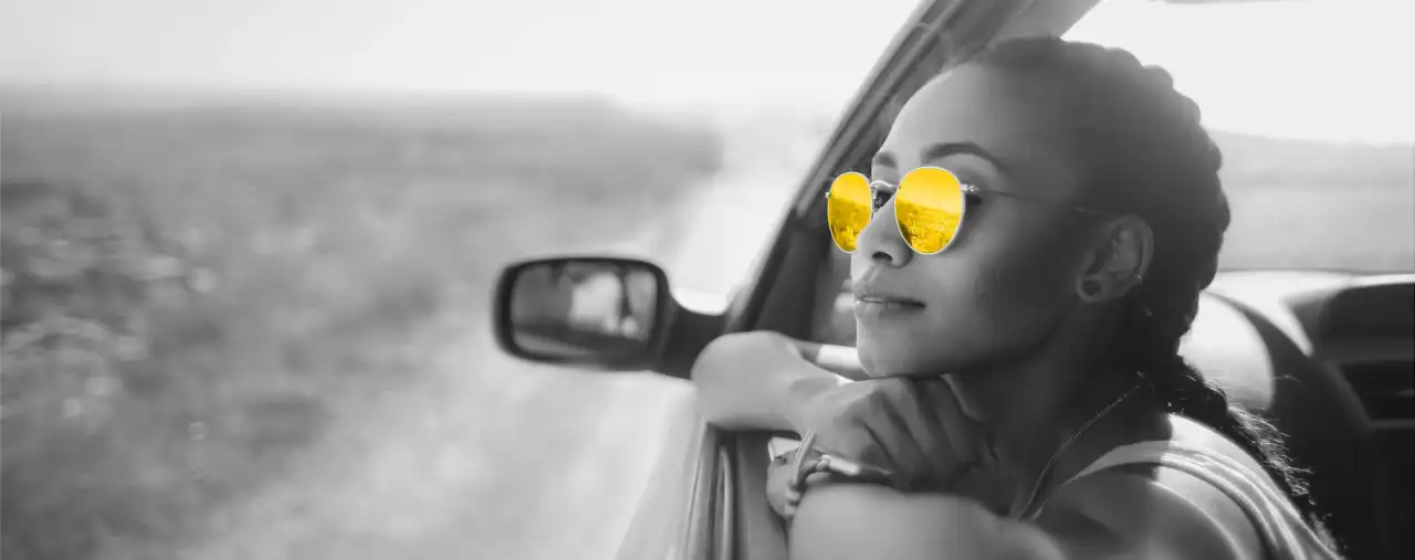 frau mit gelber sonnenbrille lehnt aus auto seitenfenster, hertz autovermietung