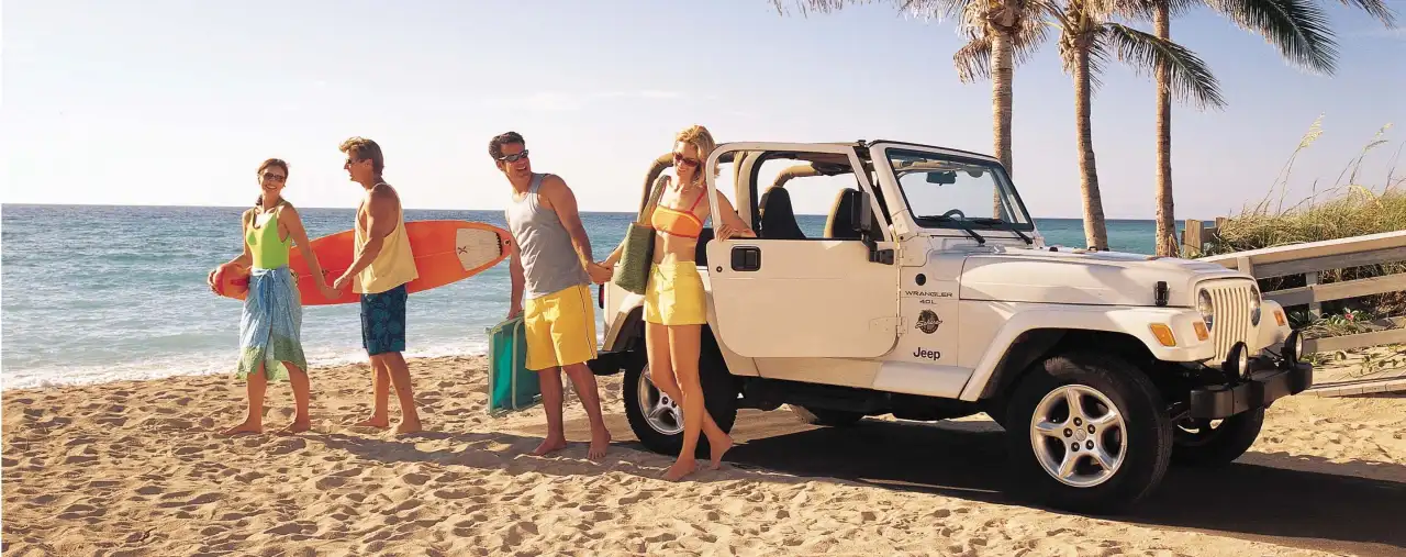 alamo jeep wrangler am Strand von hawaii, Pärchen Strandurlaub