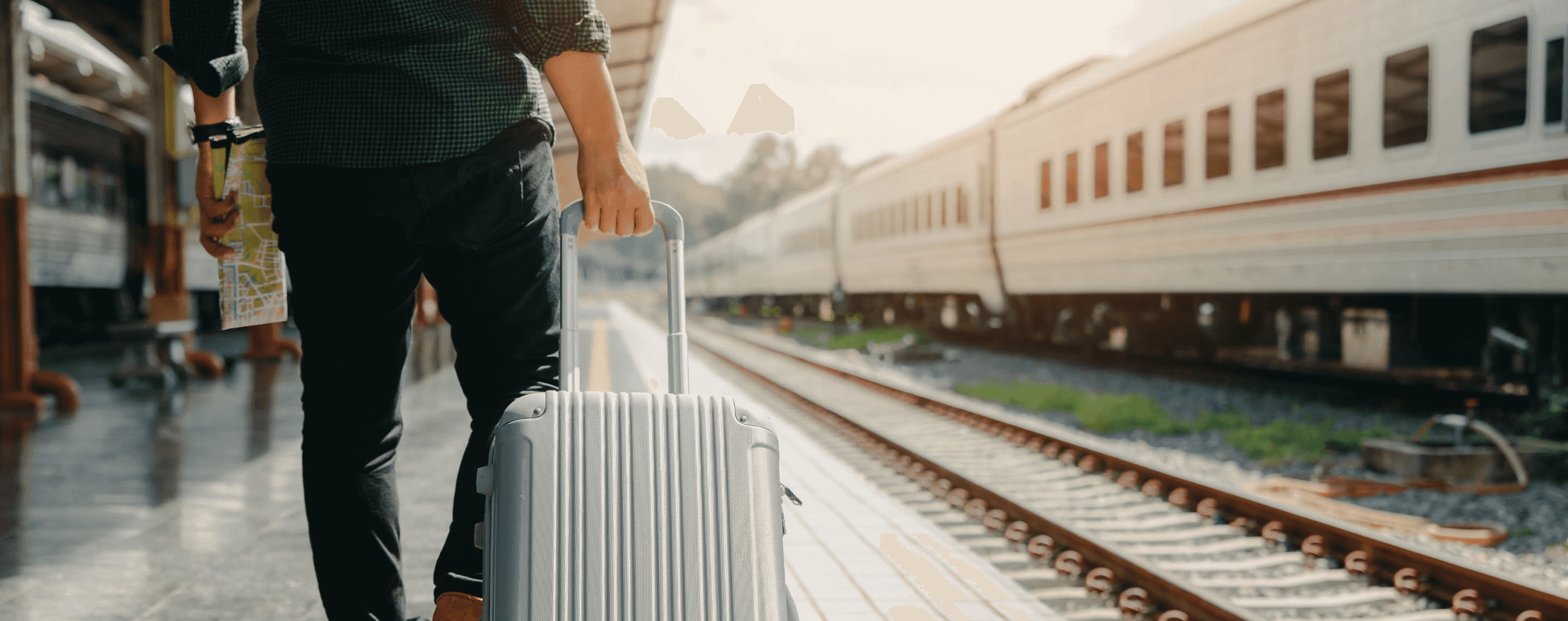 Reisender mit Koffer am Bahnhof